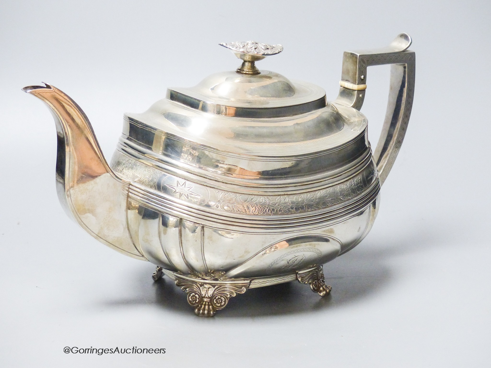 A George IV silver shaped oval teapot, by Naphthali Hart, London, 1824, with reeded and floral bands, on winged paw feet, gross 26oz.